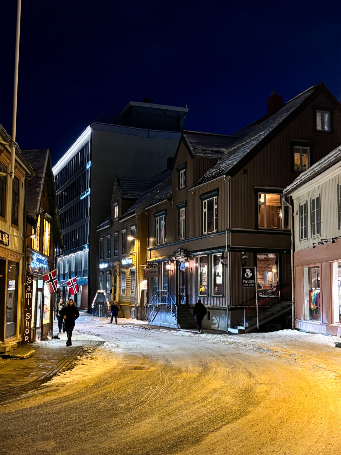 Rue de Tromsø avec drapeaux norvégiens et façades en bois