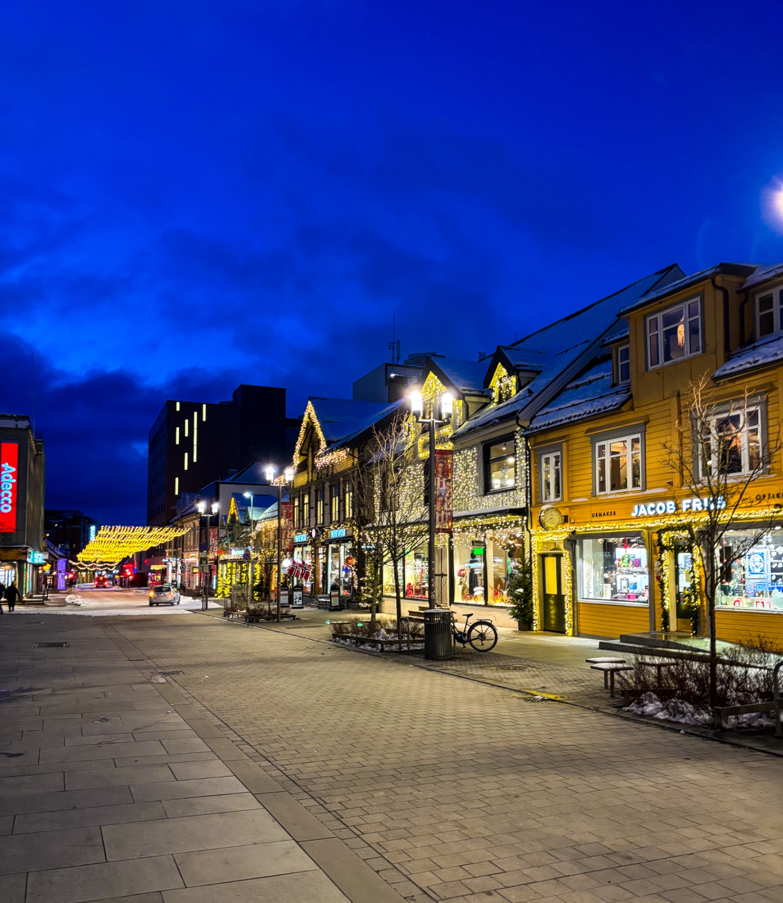 Rue piétonne de Tromsø illuminée de guirlandes de Noël à l’heure bleue