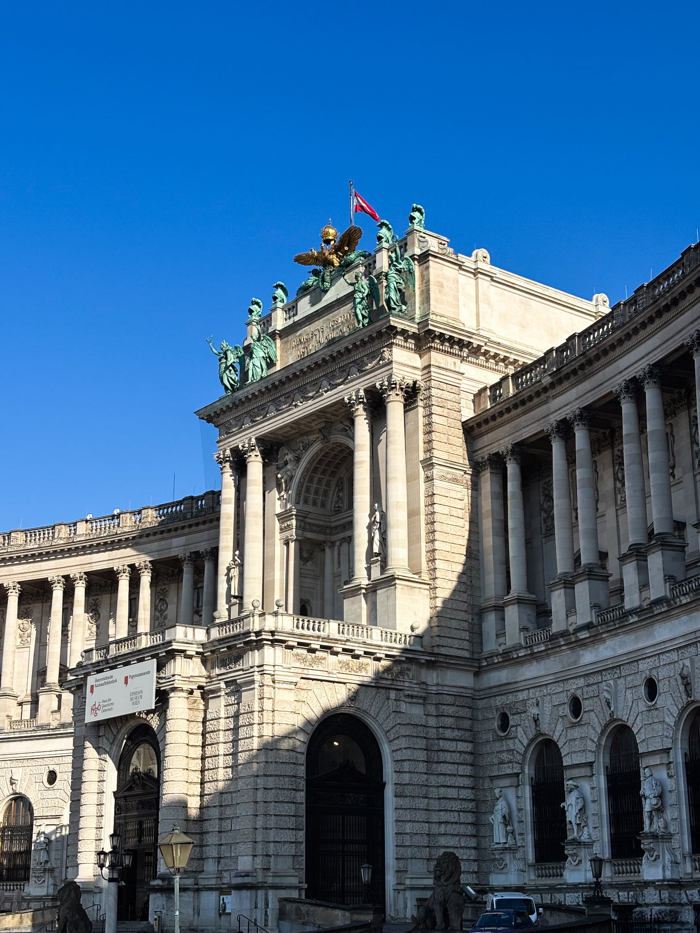 Façade monumentale de la Neue Burg au palais du Hofburg, ornée de statues et du drapeau autrichien