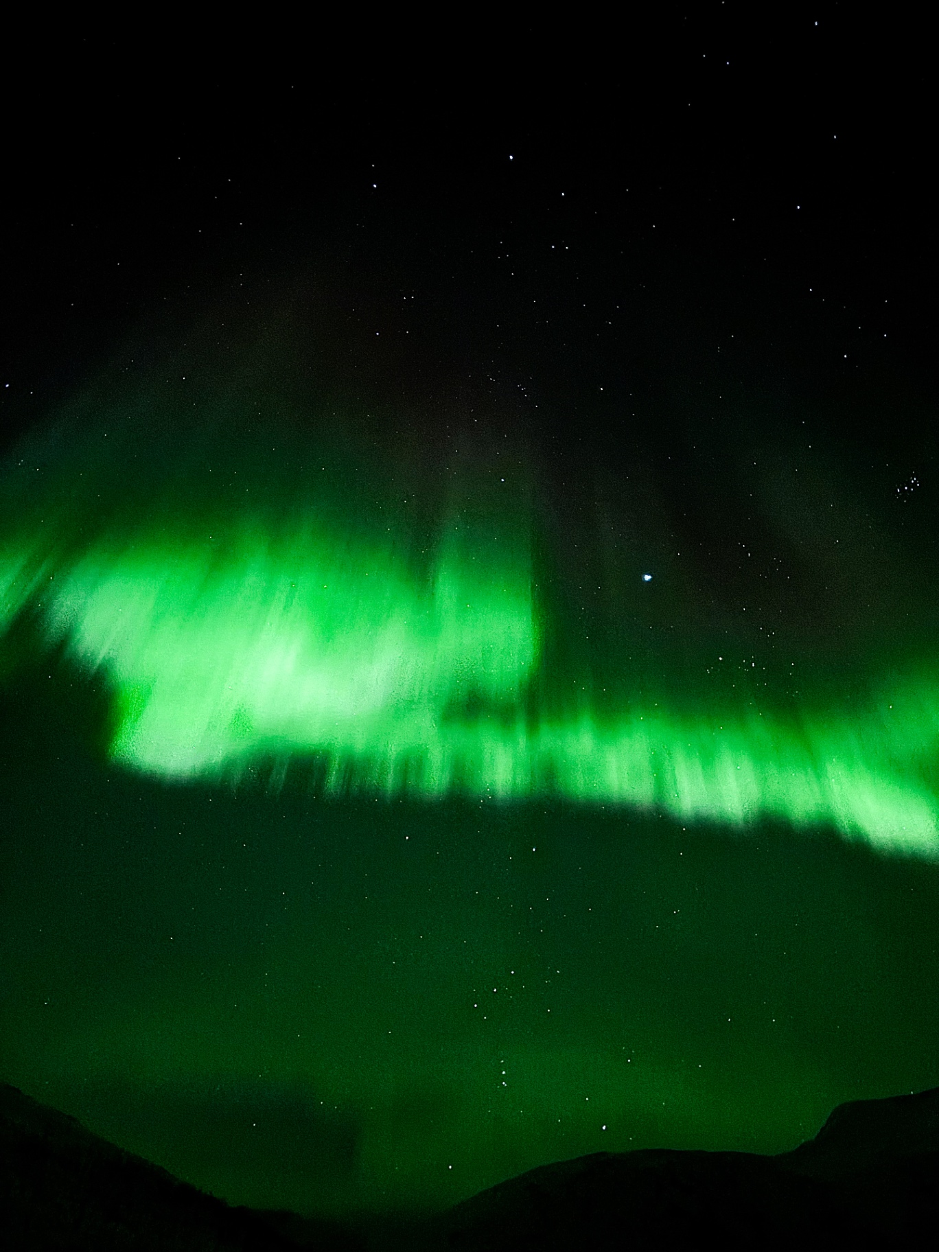Rideaux verts d’aurore boréale dans le ciel étoilé arctique