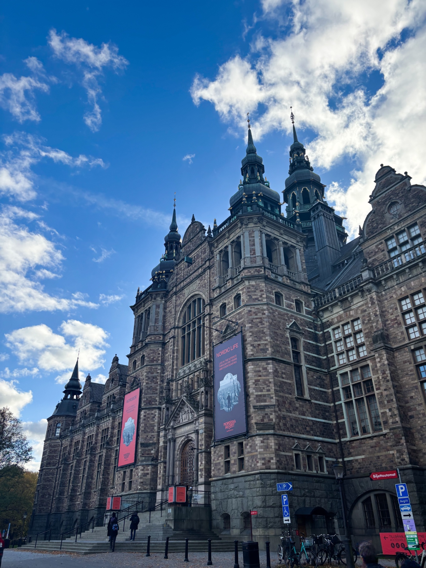 Façade richement ornée du Nordiska Museet sur Djurgården, sous un ciel bleu à nuages