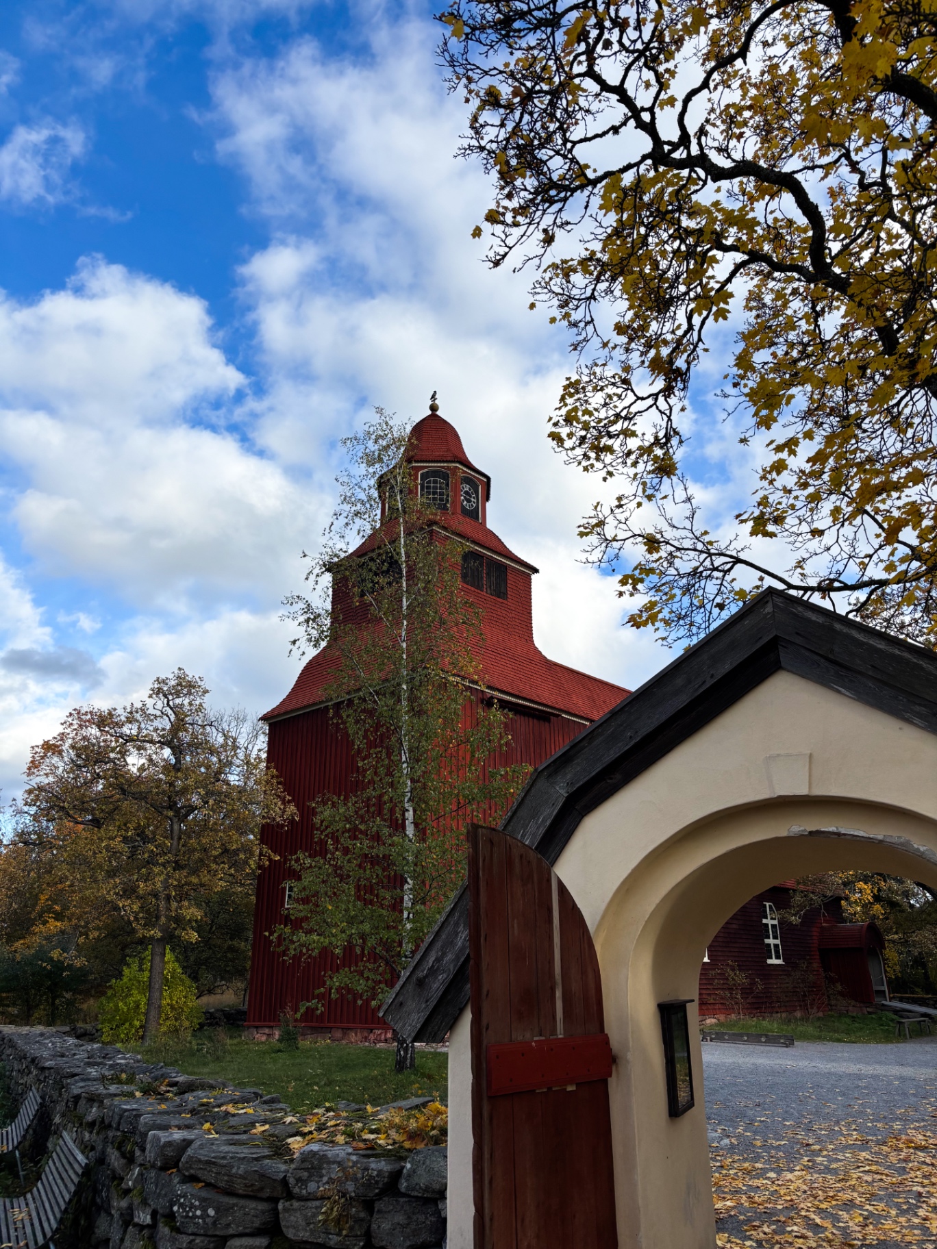 Clocher rouge de Skansen vu à travers un porche et un portail de bois