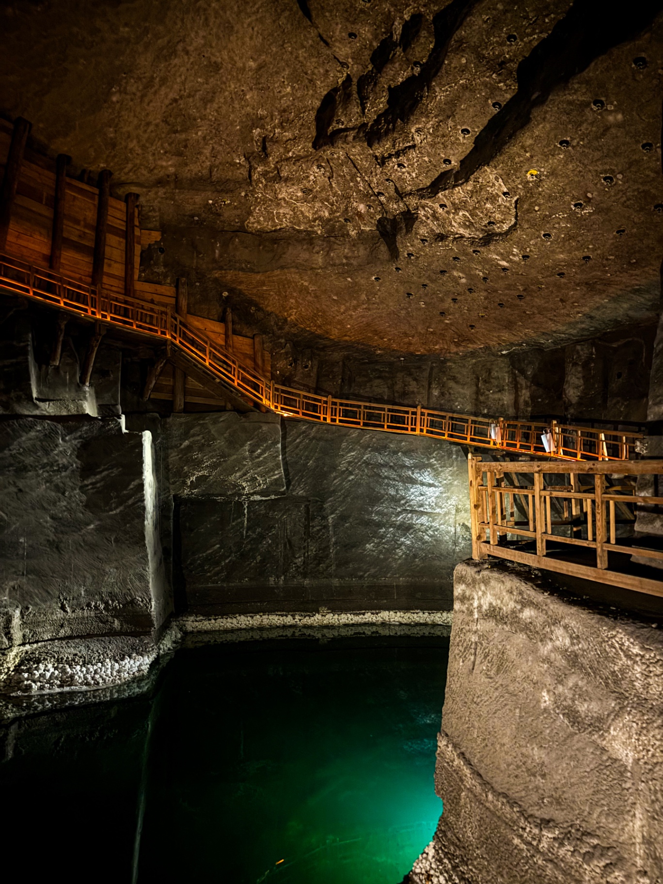 Lac souterrain aux eaux émeraude entouré de passerelles et d'escaliers de bois