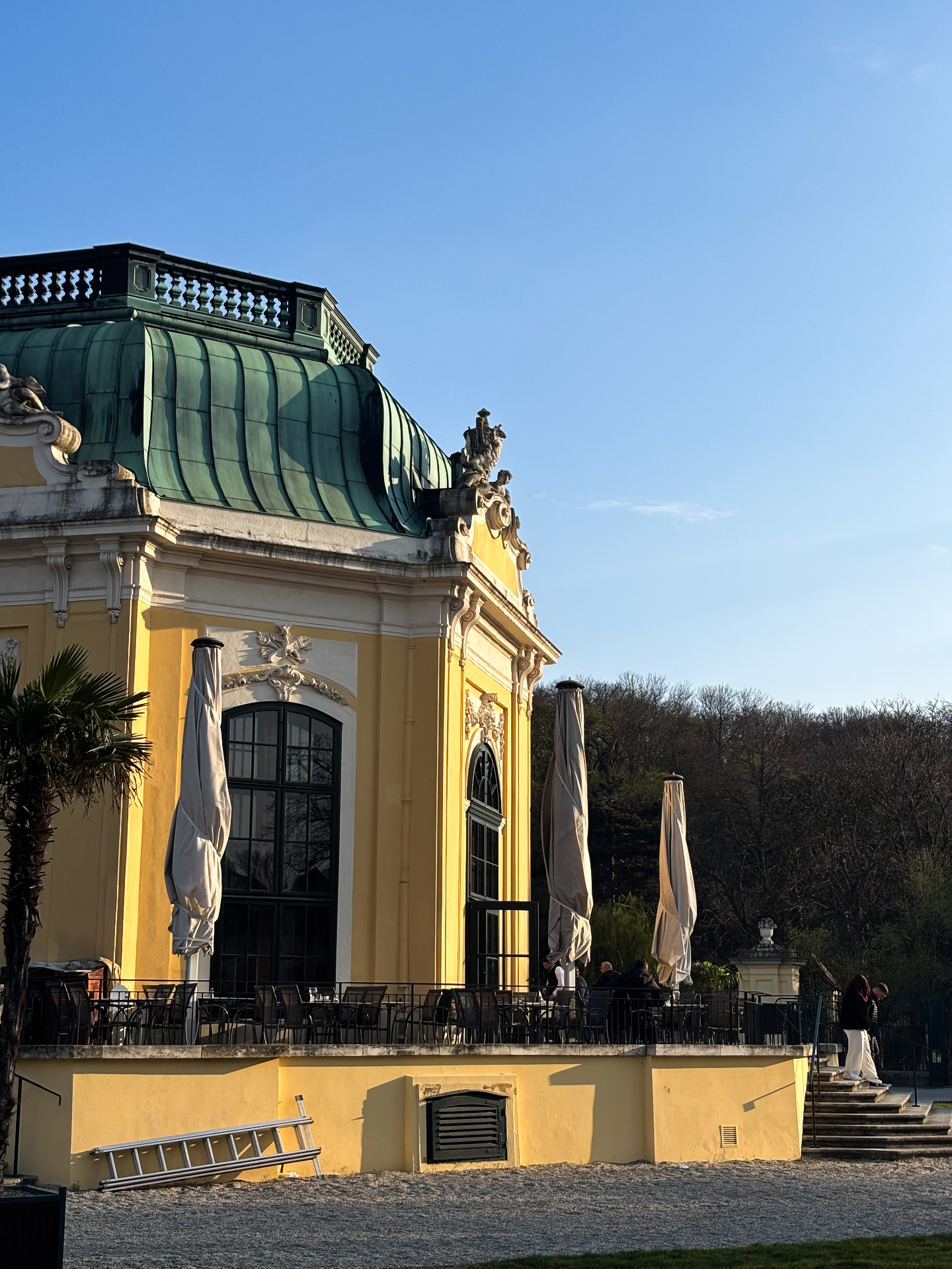Pavillon baroque jaune à toit de cuivre vert dans les jardins de Schönbrunn, parasols de café fermés