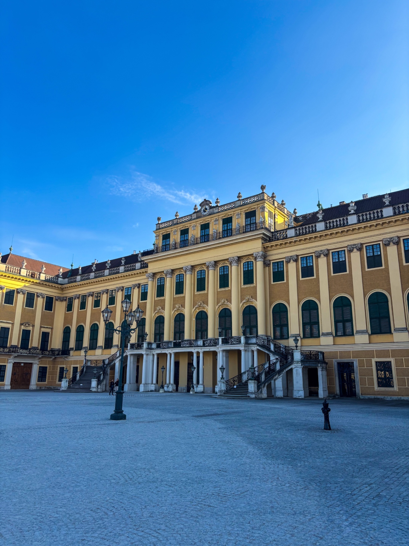 Façade jaune et cour d’honneur du château de Schönbrunn sous un ciel bleu