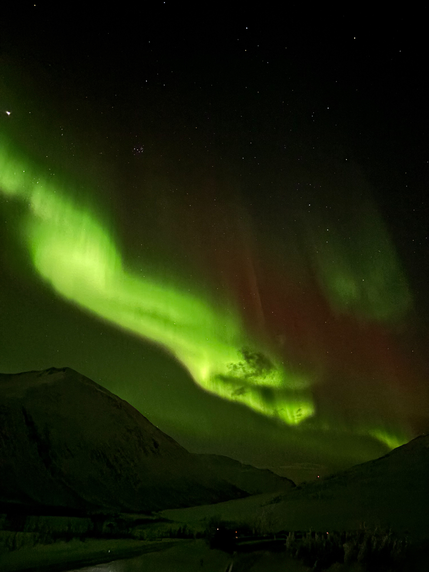 Aurore boréale verte et rouge au-dessus des fjords de Tromsø