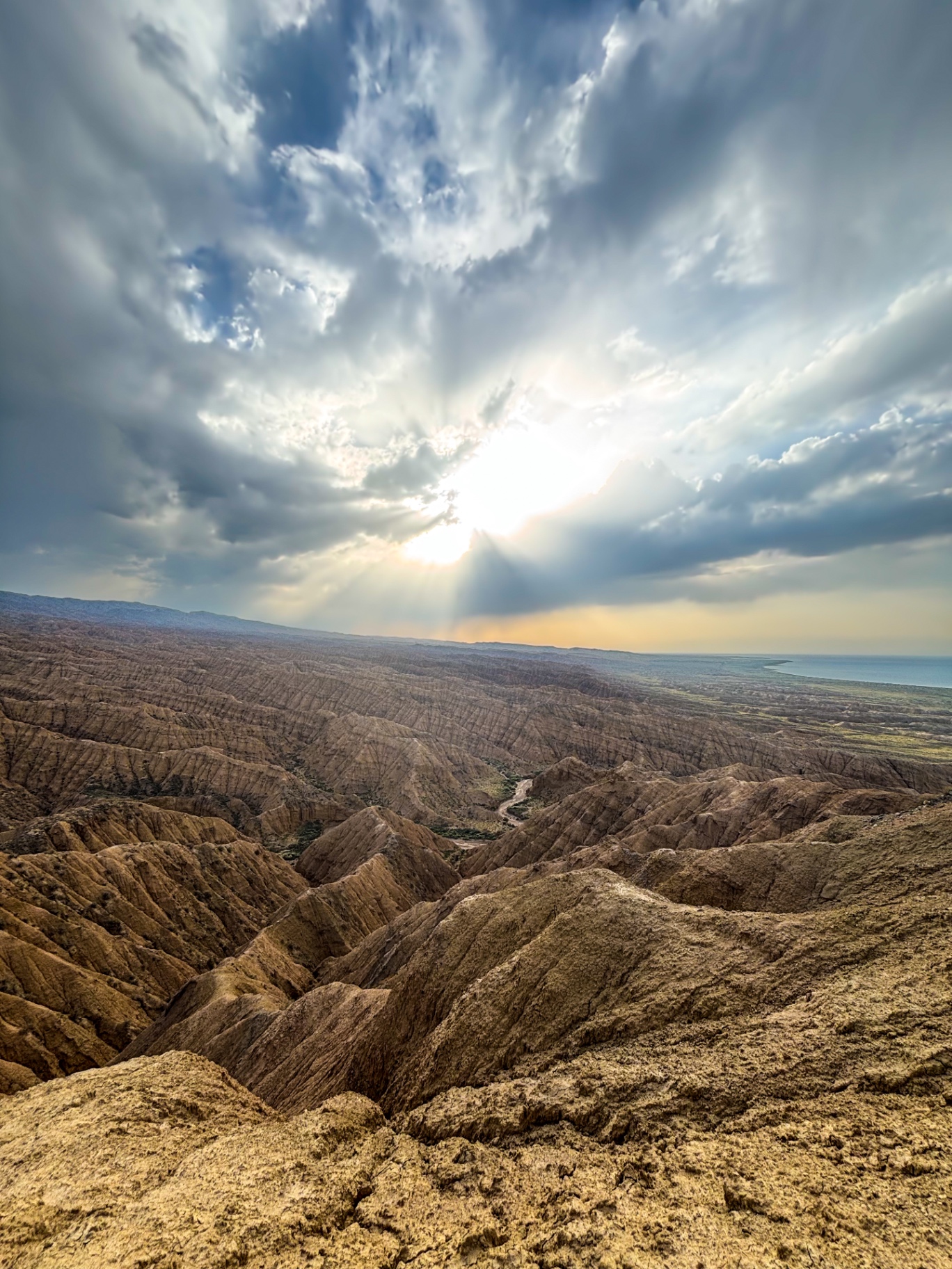 Rayons de soleil percant les nuages au-dessus du canyon et du lac Issyk-Kul
