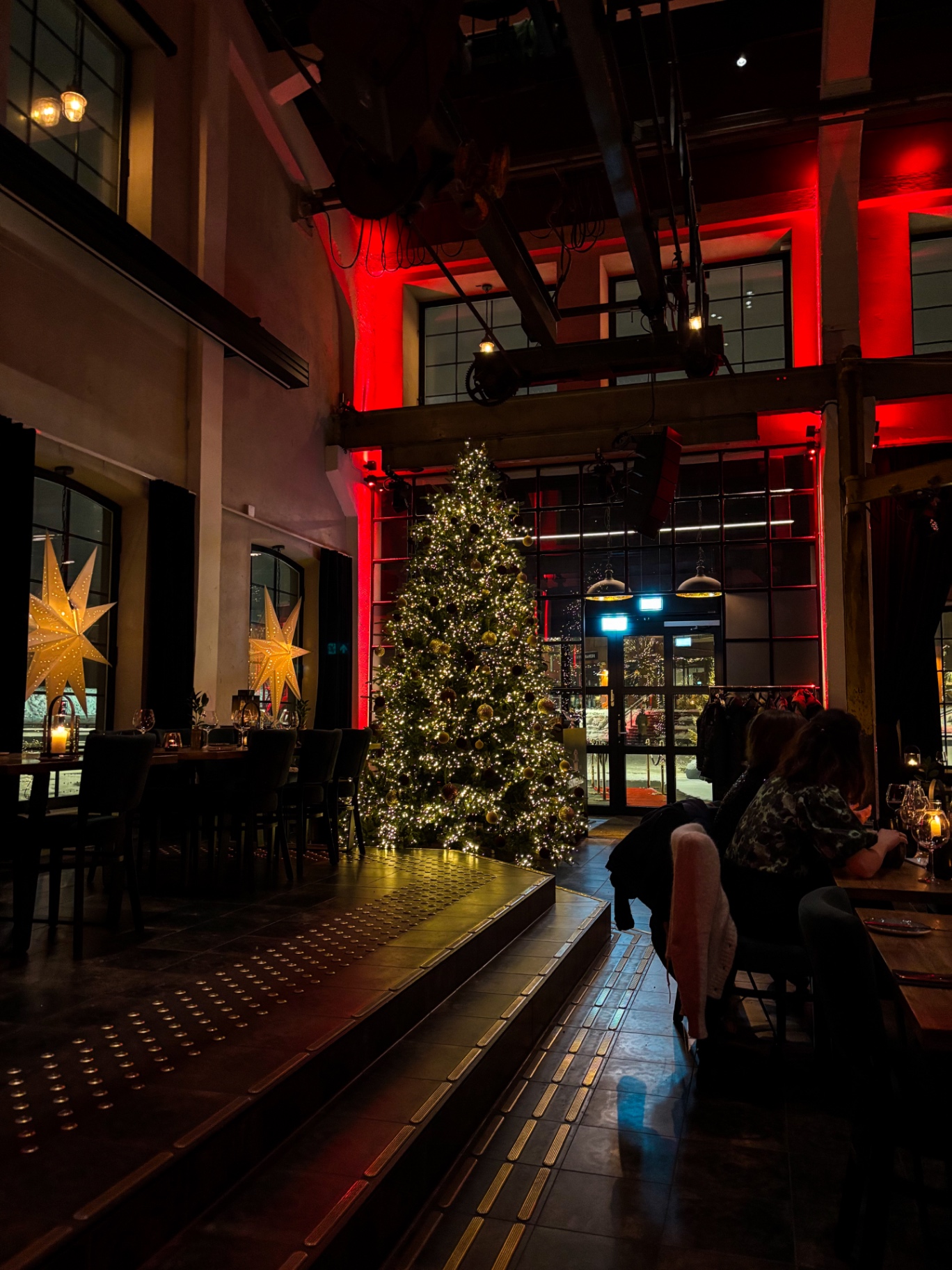 Intérieur du restaurant Maskinverkstedet avec un grand sapin de Noël illuminé