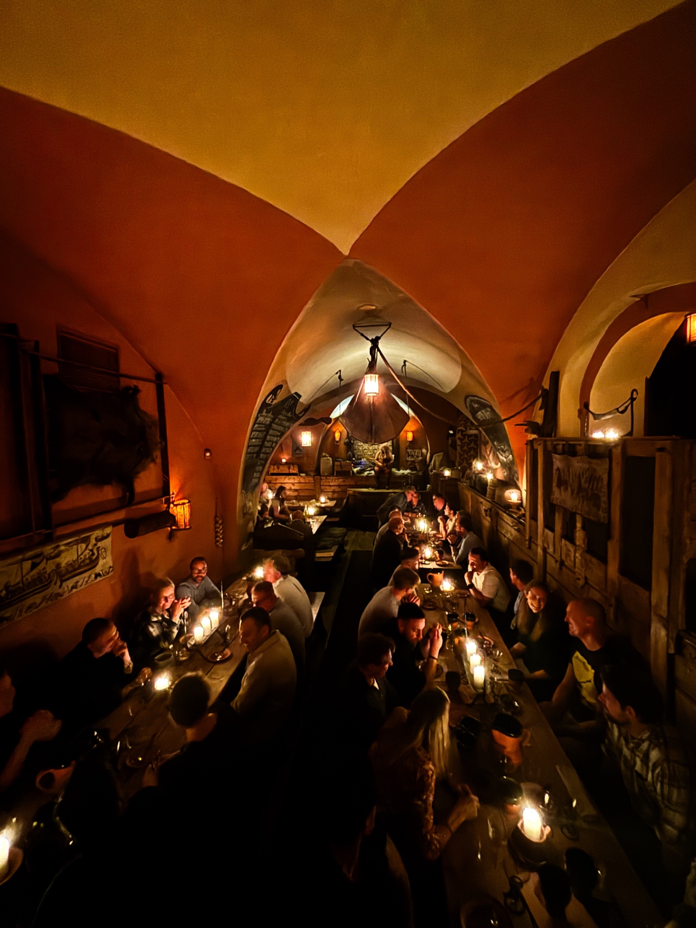 Voûte orange de l'Aifur, tables à la chandelle et musicien au fond