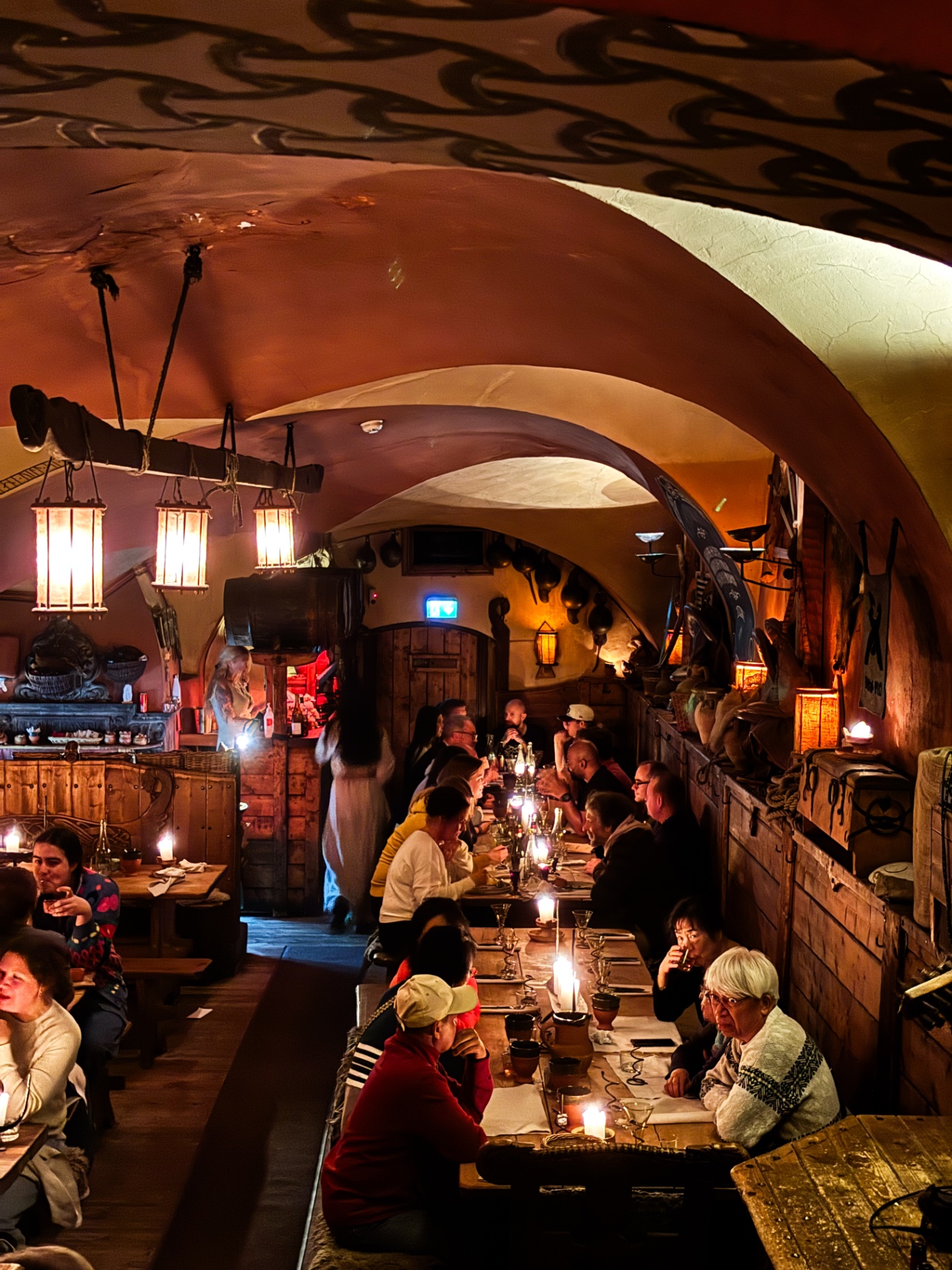 Grande salle voûtée de l'Aifur Krog & Bar, tables communes éclairées aux lanternes